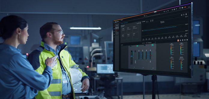 Office Meeting: Confident Female Project Manager to Chief Engineer, Watching Interactive Digital Whiteboard TV that Shows Green Screen Chroma Key Display. Factory with Machinery.